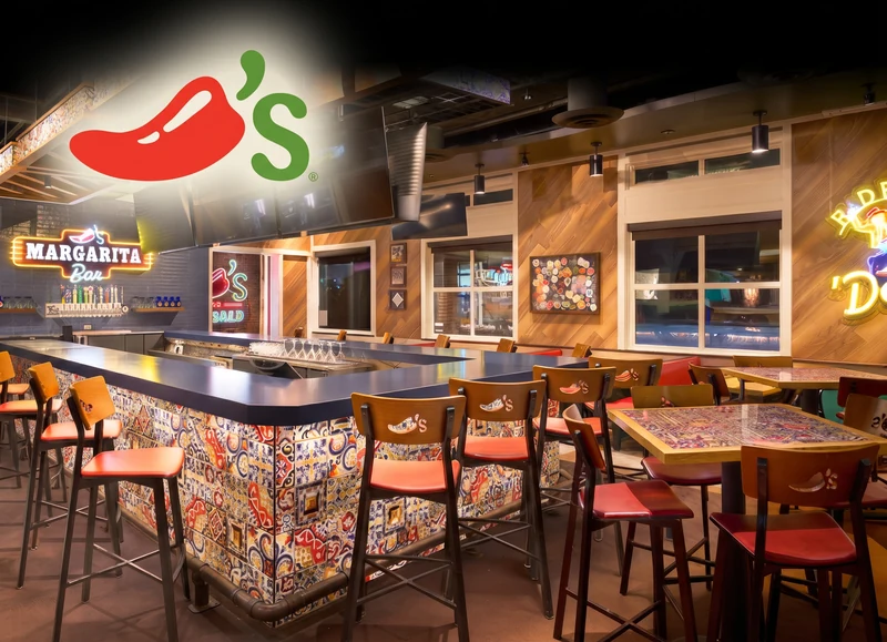 Chili's Grill and Bar restaurant interior with a colorful bar counter, timber chairs and warm lighting