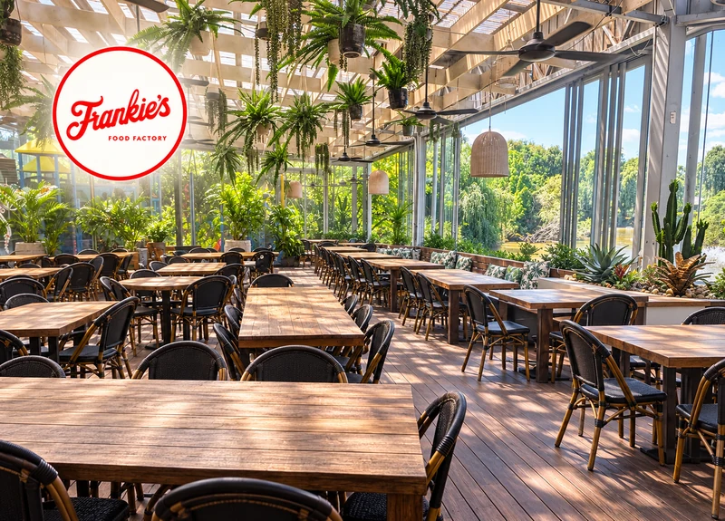 Frankie's Food Factory botanical dining room with timber tables, abundant greenery and natural light