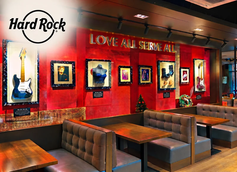 Hard Rock Cafe restaurant interior with red gallery wall, guitars and upholstered dining booths