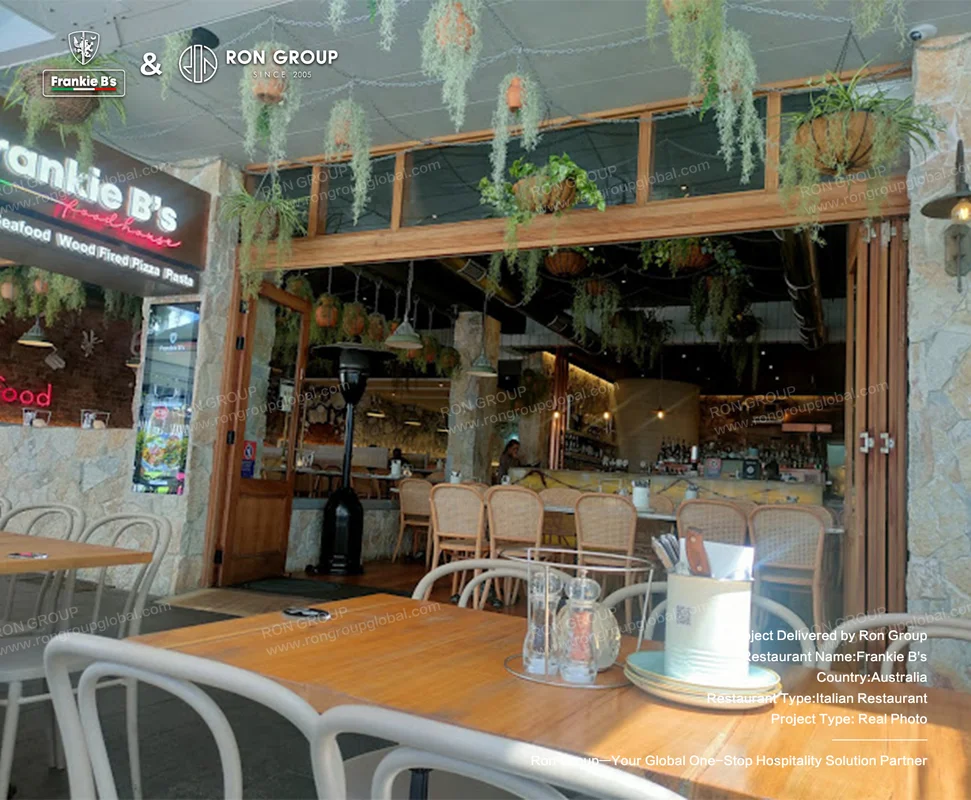 Outdoor dining area at Frankie B's with plant decor and weather-resistant furniture