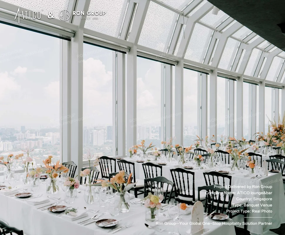 ATICO elegant banquet setup with city view white tables black chairs and peach floral centerpieces