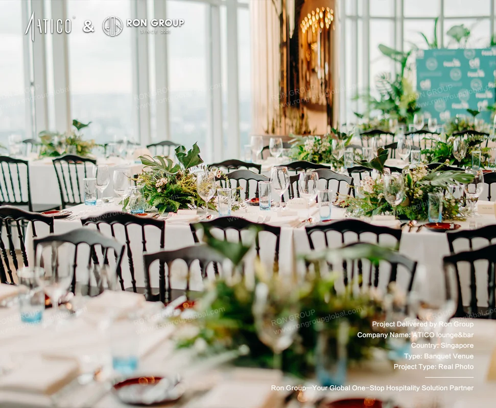 ATICO elegant banquet table setting with greenery floral centerpieces white linens black chairs and city view