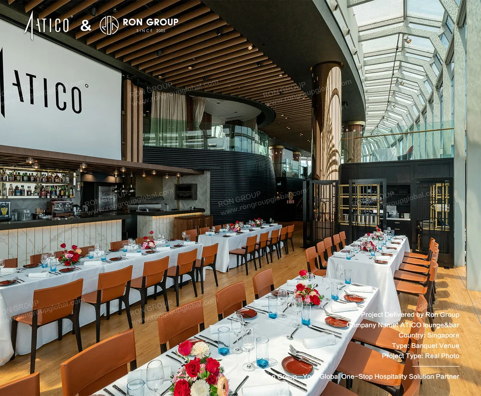 ATICO modern banquet hall interior with long dining tables white linens floral centerpieces leather chairs and bar area