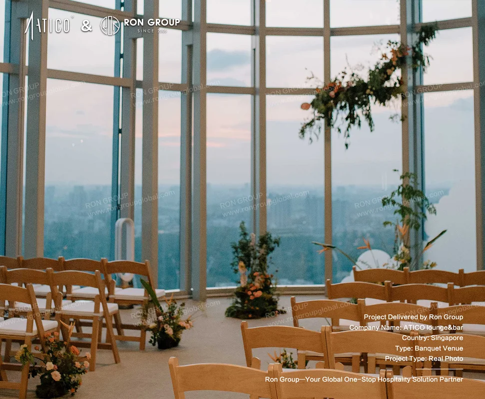 ATICO wooden chairs facing large windows with floral decorations for ceremony or event setup