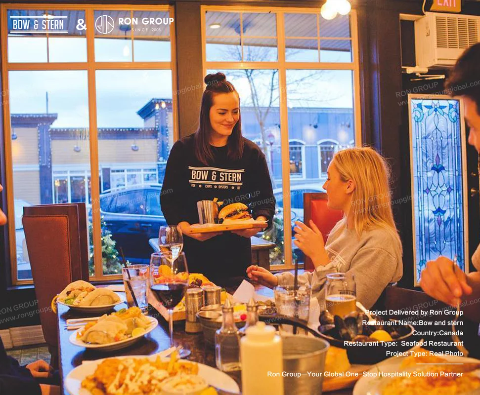 Bow and Stern server delivering food in a warm restaurant setting
