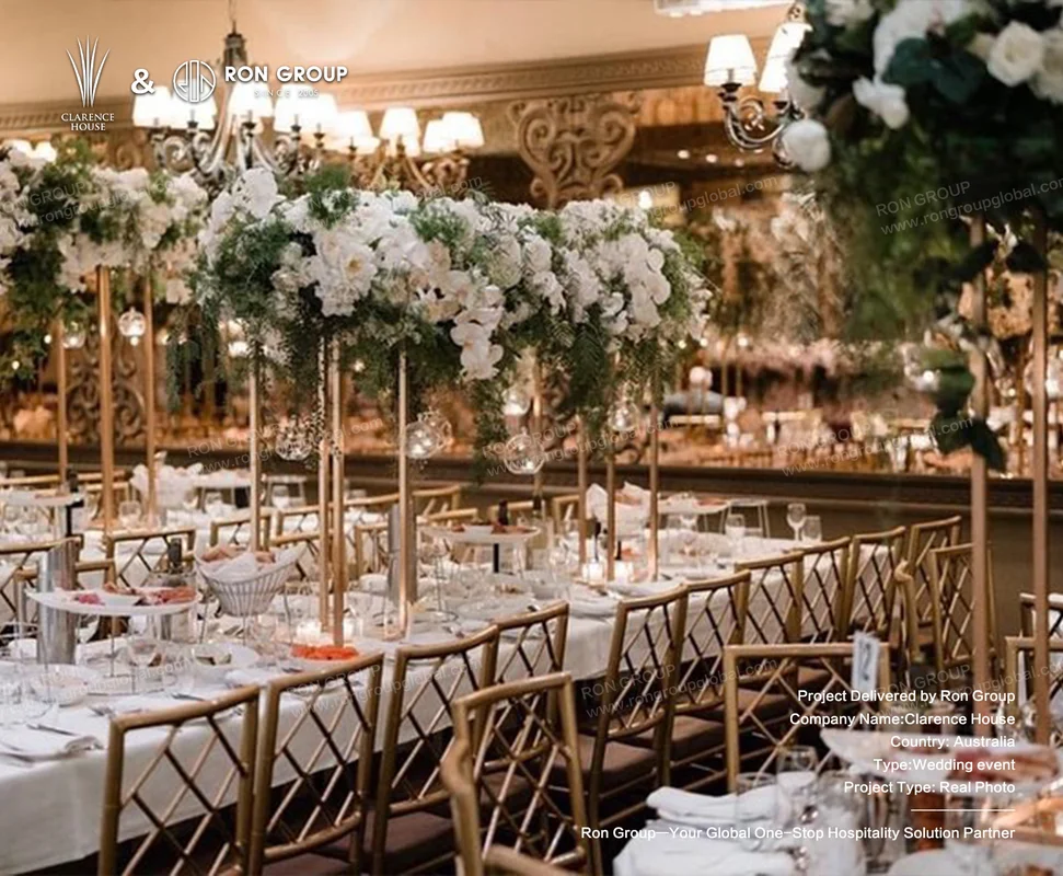 Clarence House long wedding tables with floral arches and gold chairs