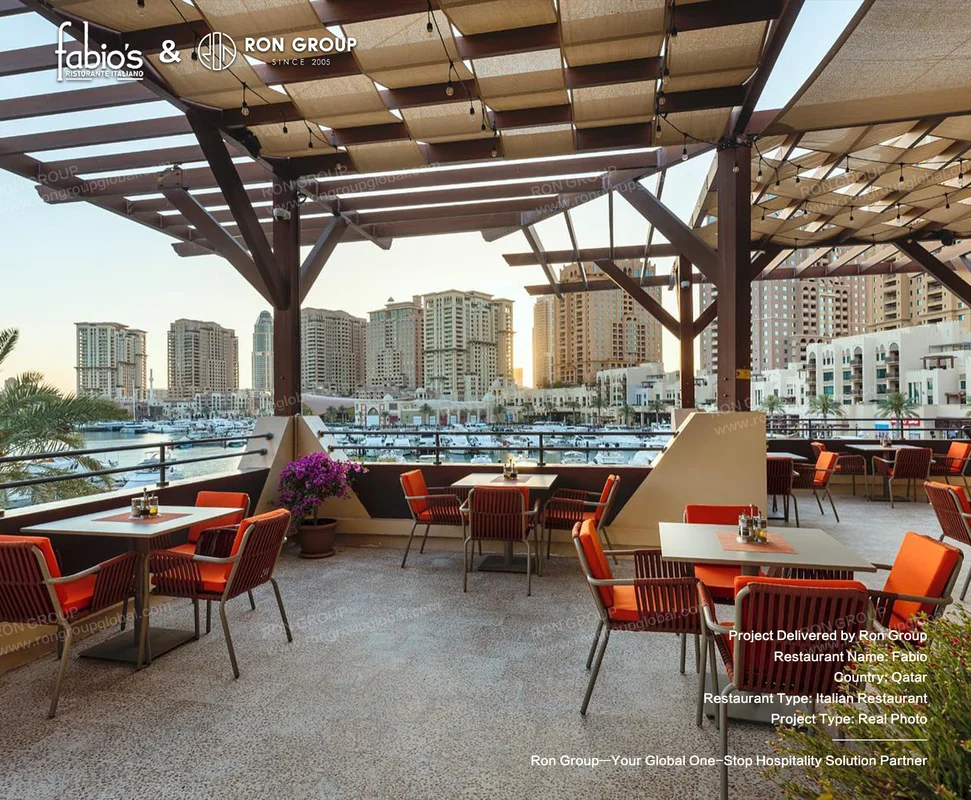 Fabio outdoor restaurant terrace with orange cushioned chairs wooden pergola marina and high rise skyline
