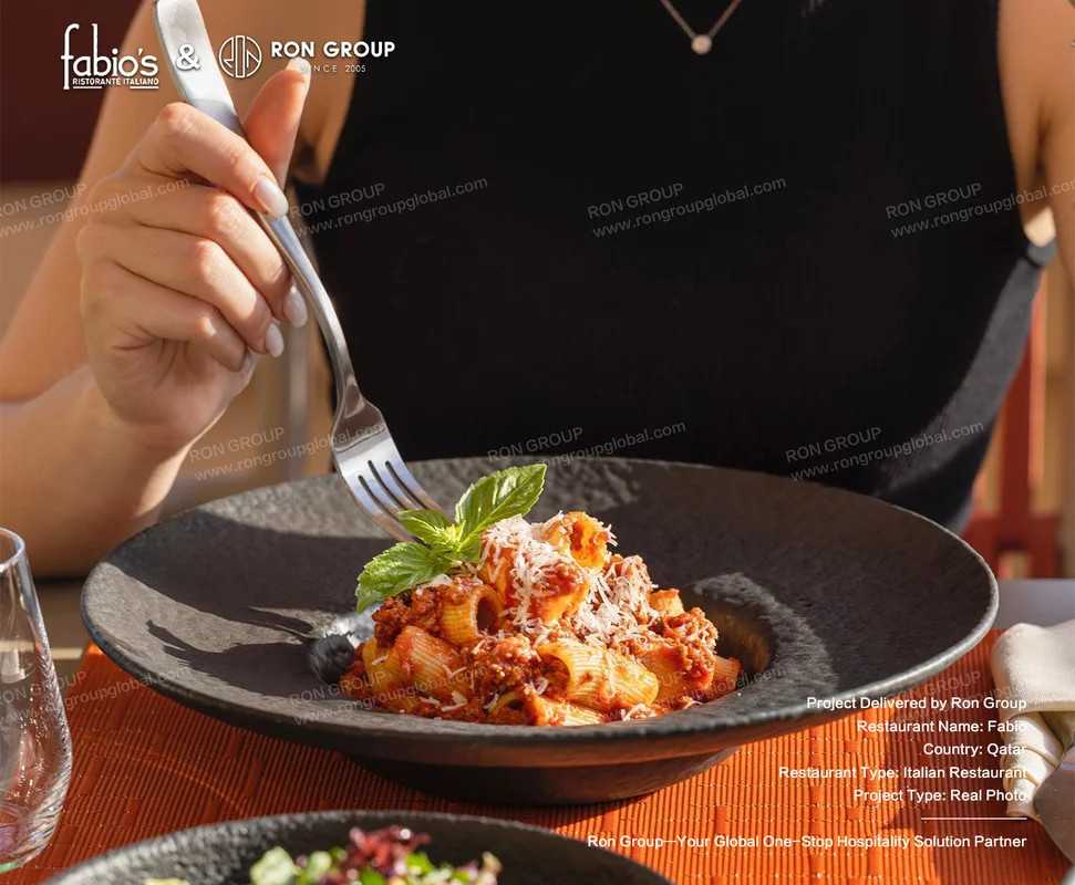 Fabio pasta dish with basil tomato sauce cheese and table setting