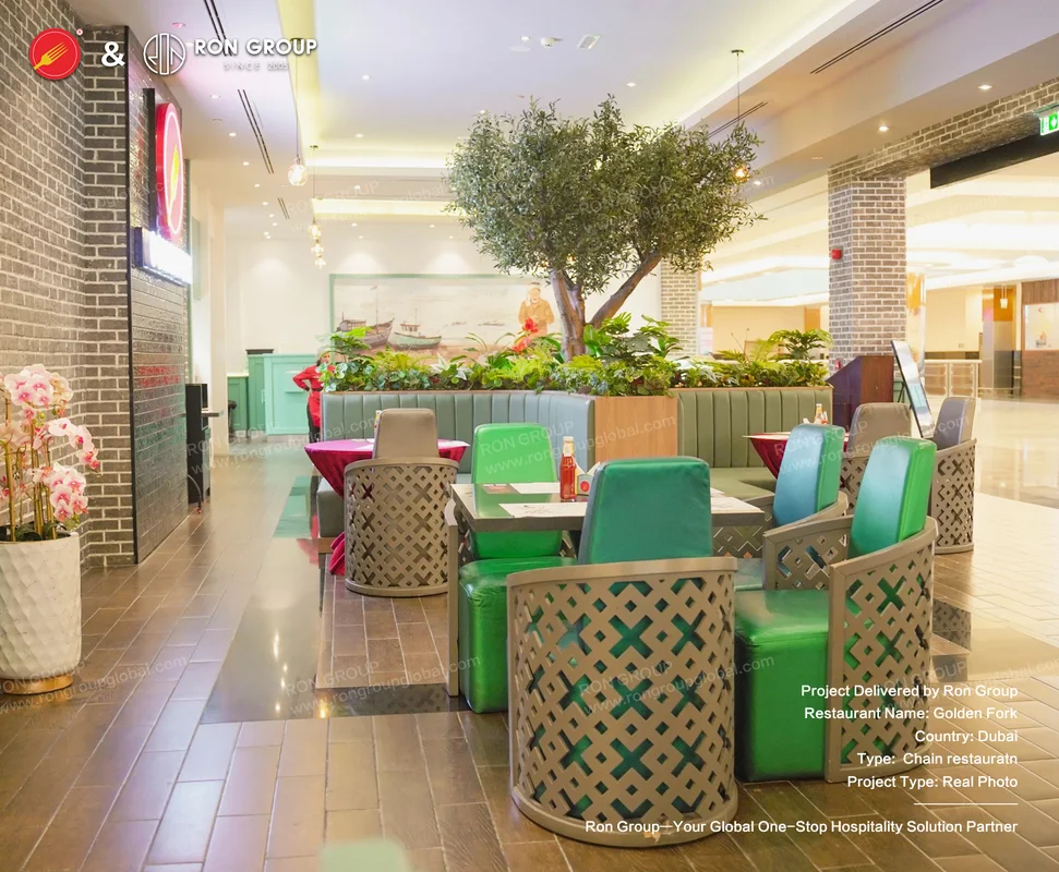 Green upholstered chairs with olive tree centrepiece