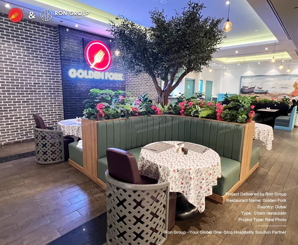 Golden Fork interior with green tufted booths and central tree