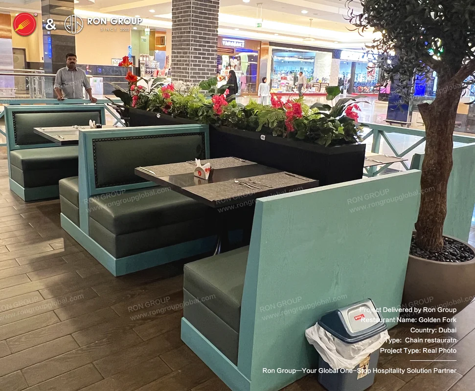 Teal and black booths in mall setting with red flowers