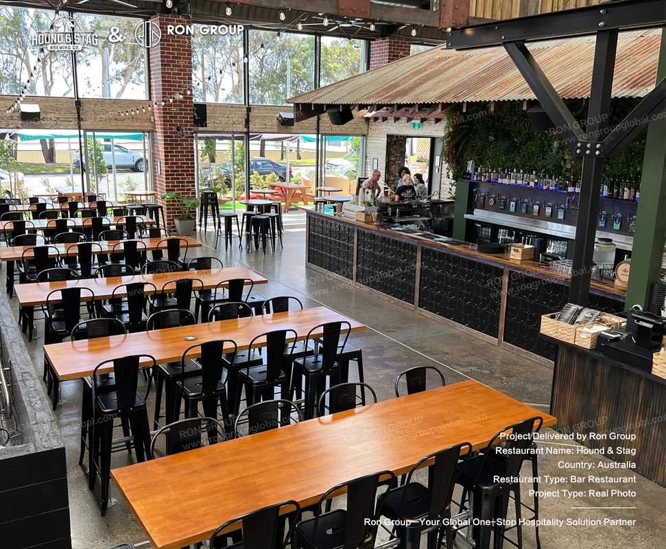 Hound Stag industrial bar restaurant interior with wooden tables black metal chairs beer taps and green wall