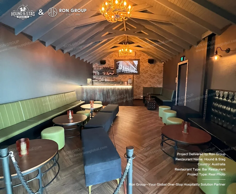 Hound Stag rustic bar interior with vaulted timber ceiling stone walls green seating and round tables