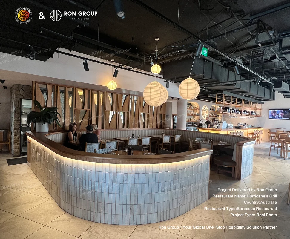 Curved tiled booth with pendant lights and bar backdrop