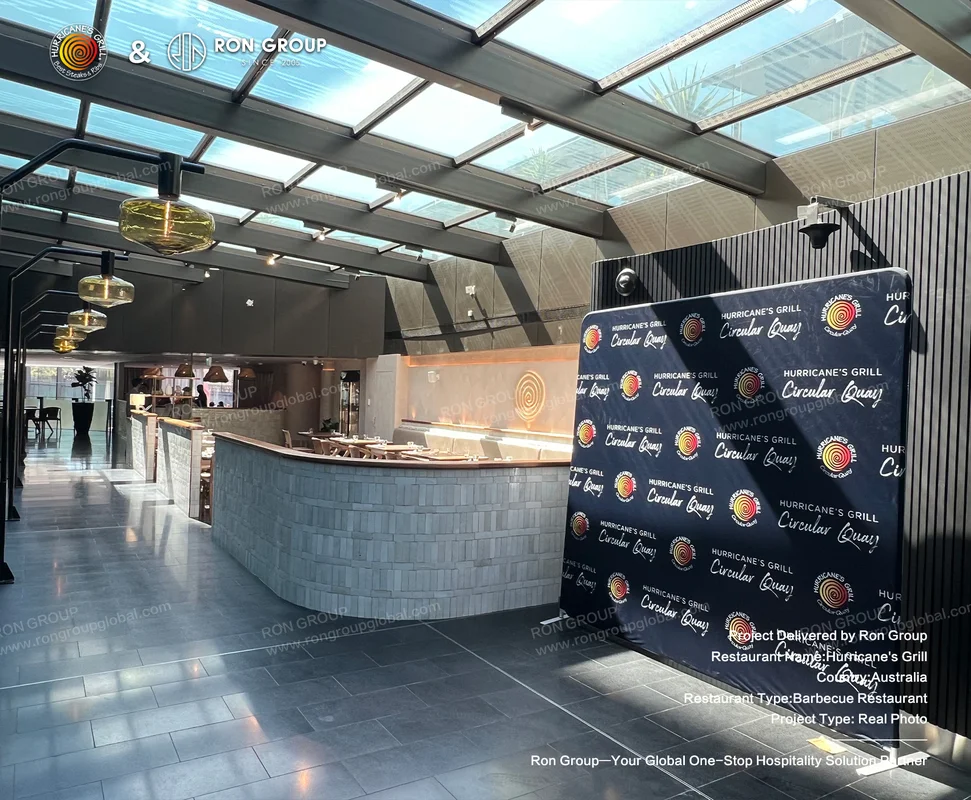 Glass-ceilinged dining space with curved bar and brand backdrop