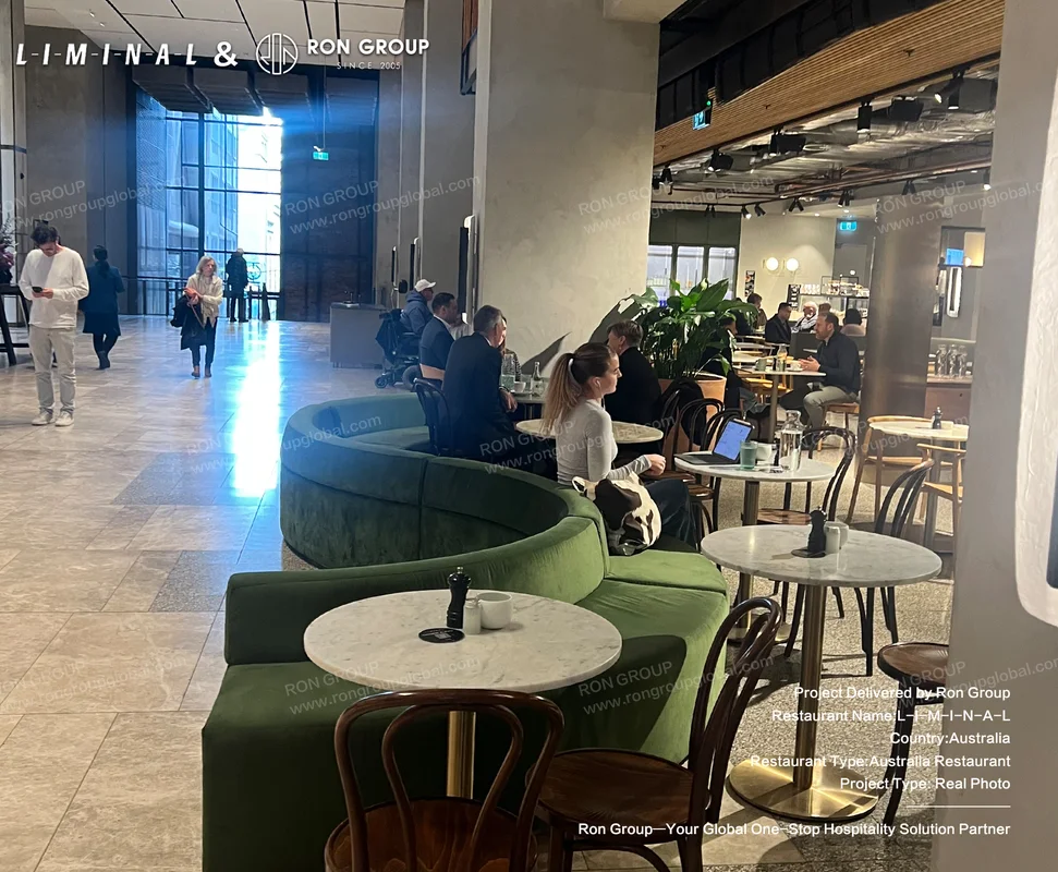 Green upholstered seating and marble cafe tables