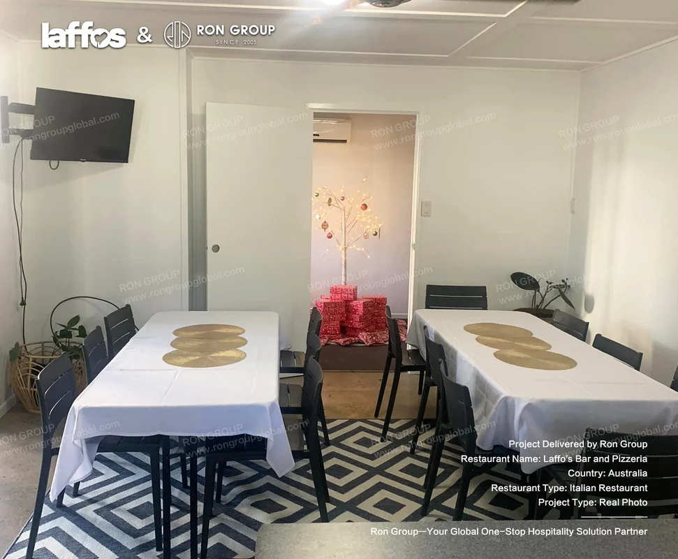 Laffos Bar and Pizzeria dining room with white tables black chairs and festive decoration