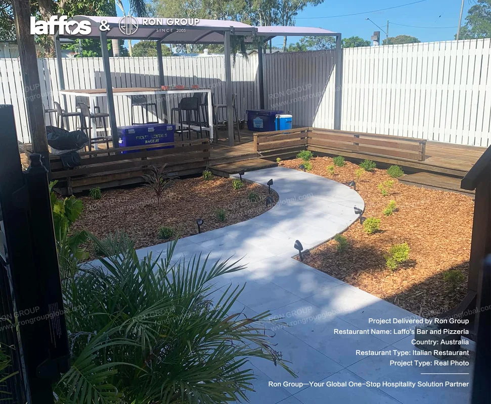 Laffos Bar and Pizzeria outdoor patio with curved path wooden deck covered seating and garden beds