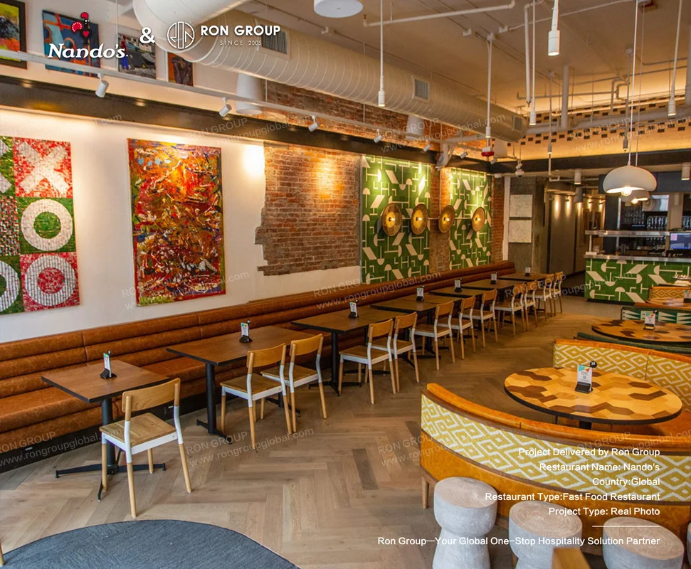 Nando's colorful wall art and light wood restaurant seating
