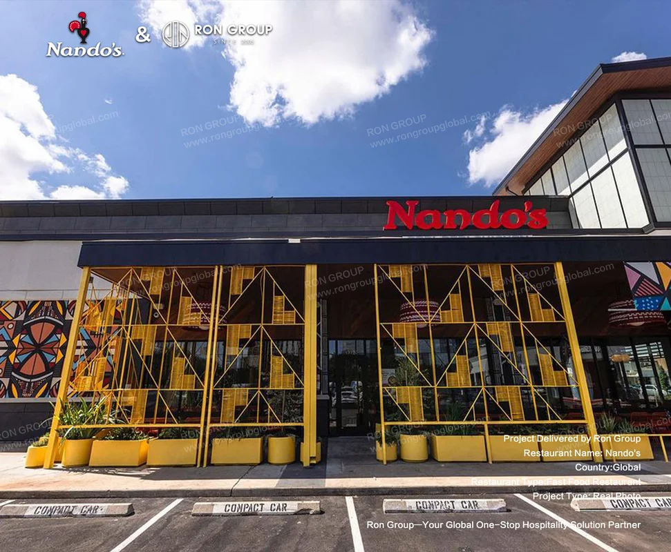 Nando's modern fast food restaurant facade with yellow frame and mosaic wall art