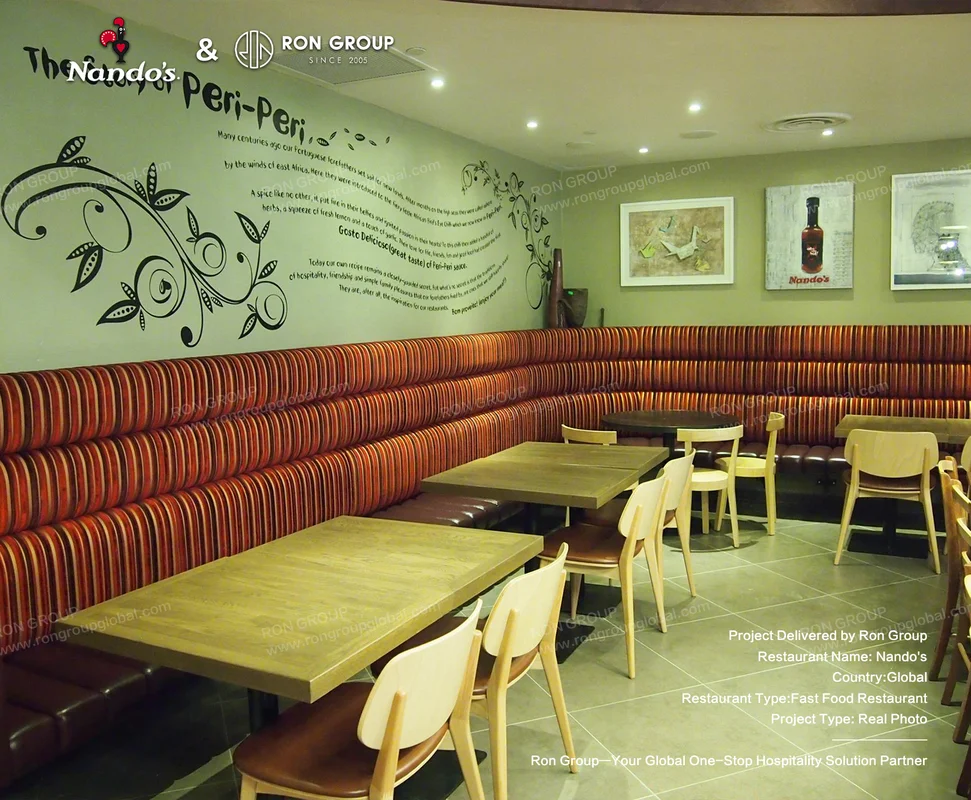 Nando's restaurant interior with curved striped booth seating and wooden tables
