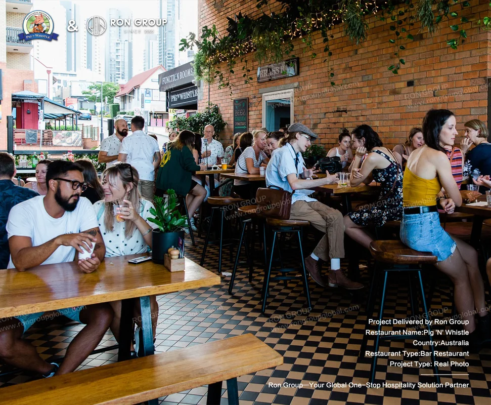 Outdoor dining area with brick walls, greenery and string lights
