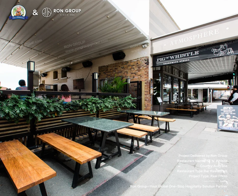 Outdoor seating with wooden benches and green tabletops