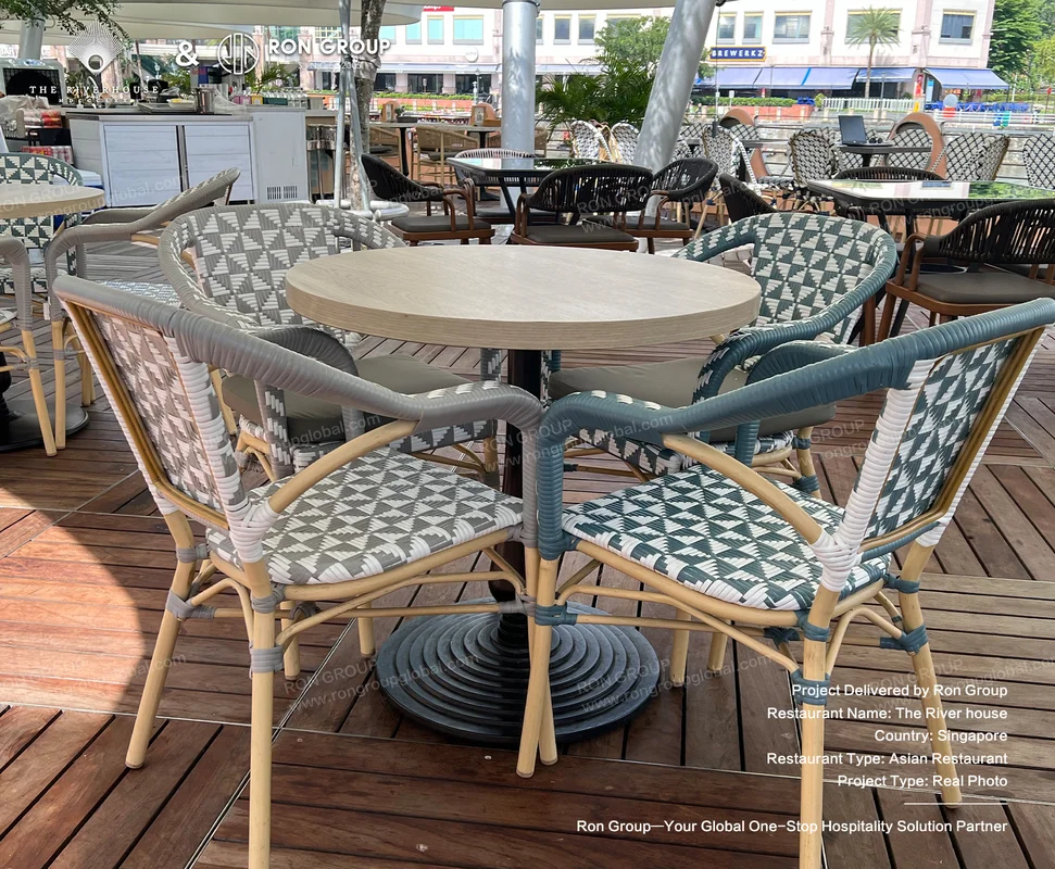 Riverhouse round wooden dining table with woven chairs geometric cushions on outdoor deck
