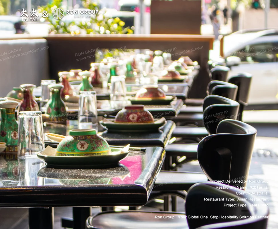 Black tables set with colourful teapots and glassware