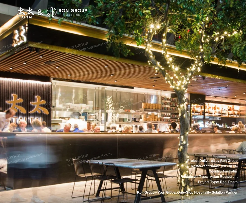 Outdoor seating with fairy-lit tree and glass-fronted interior