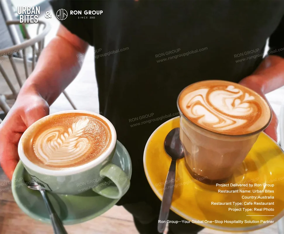 Barista holding two lattes at Urban Bites