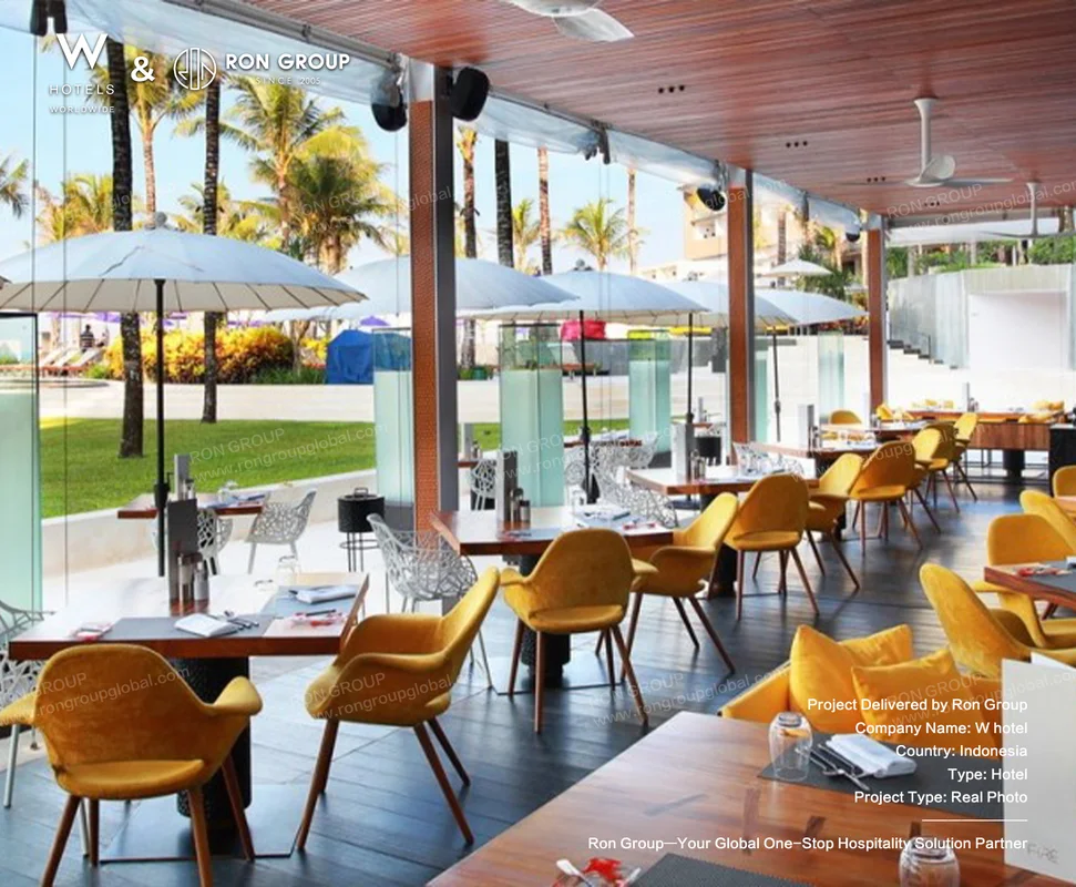 W Bali Seminyak outdoor patio dining area with umbrellas and yellow chairs