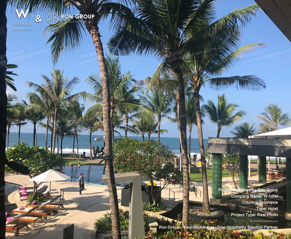 W Bali Seminyak tropical resort poolside area with palm trees and ocean view