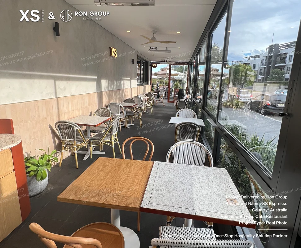 Modern cafe seating area with tables chairs and outdoor view