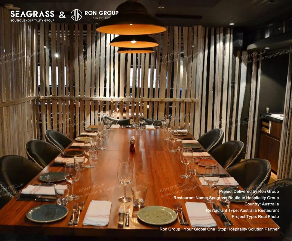 Seagrass long wooden dining table under warm pendants