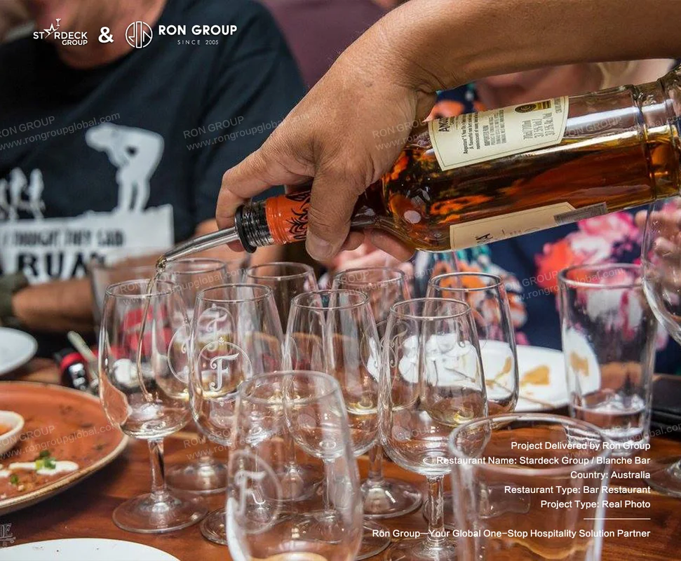 Blanche Bar RonGroup-Blanche_Bar-Hand_Pouring_Drink_Into_Glasses.webp
