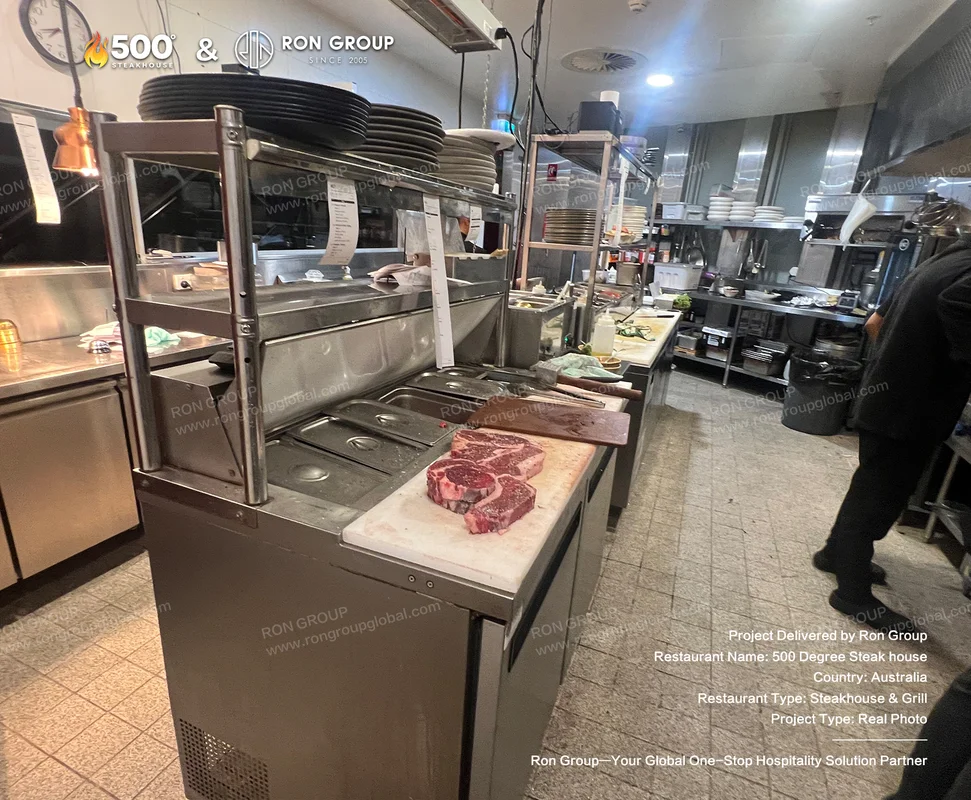 Stainless steel kitchen interior with marble cutting board at 500 Degrees Steakhouse