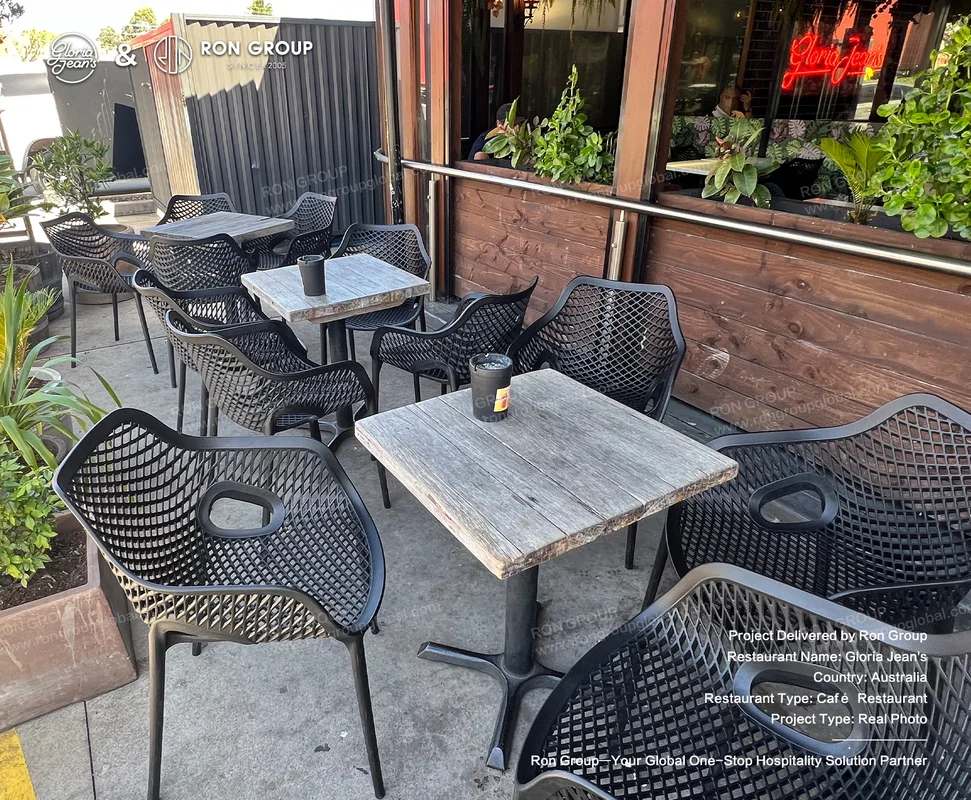 Black mesh chairs with wooden tables on the Gloria Jean's patio