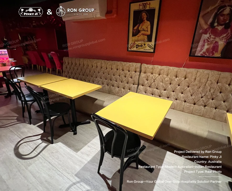 Pinky Ji yellow tables and tufted booths