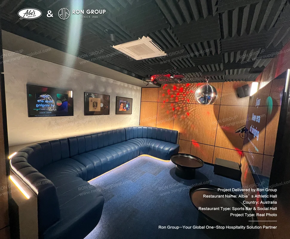 Curved blue leather sectional sofa in private karaoke lounge with disco ball lighting
