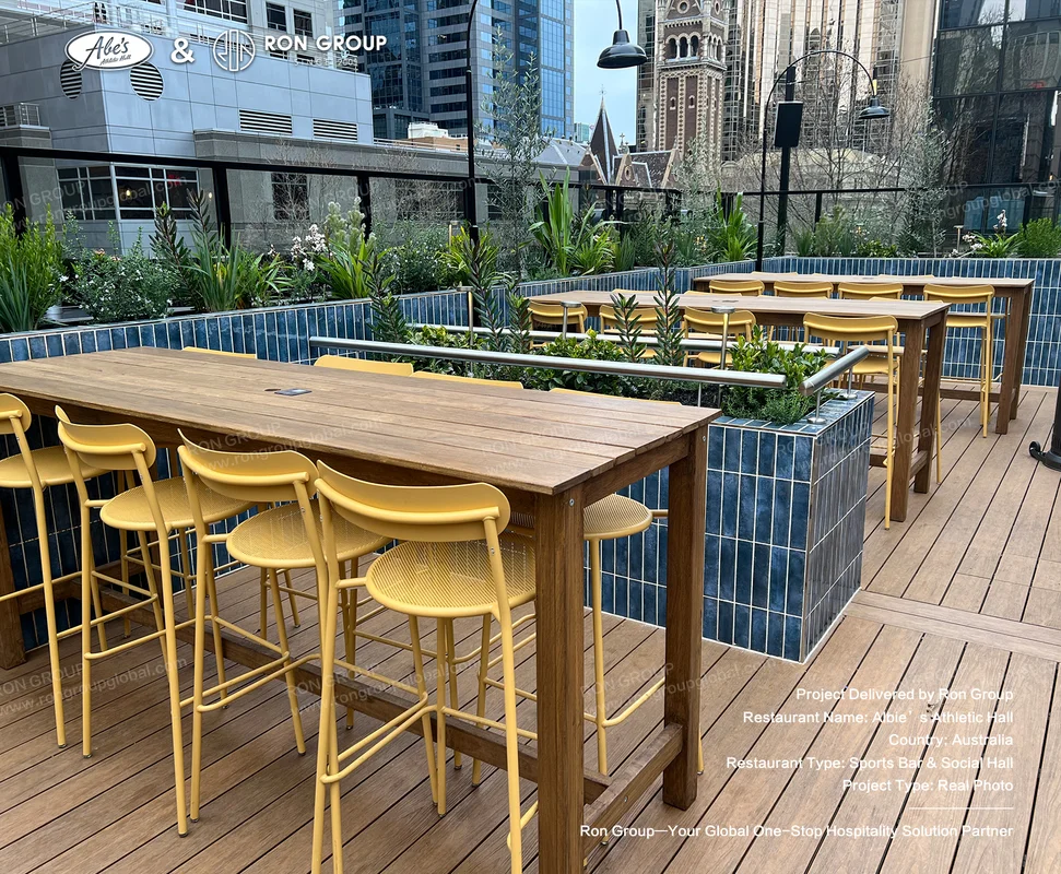 Melbourne CBD rooftop terrace with wooden high tables yellow metal stools and blue-tiled planters