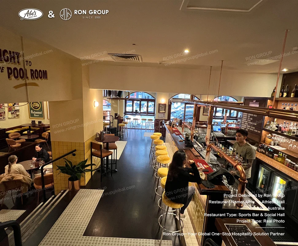 Abe's Athletic Hall Melbourne main timber bar with yellow metal stools and arched windows