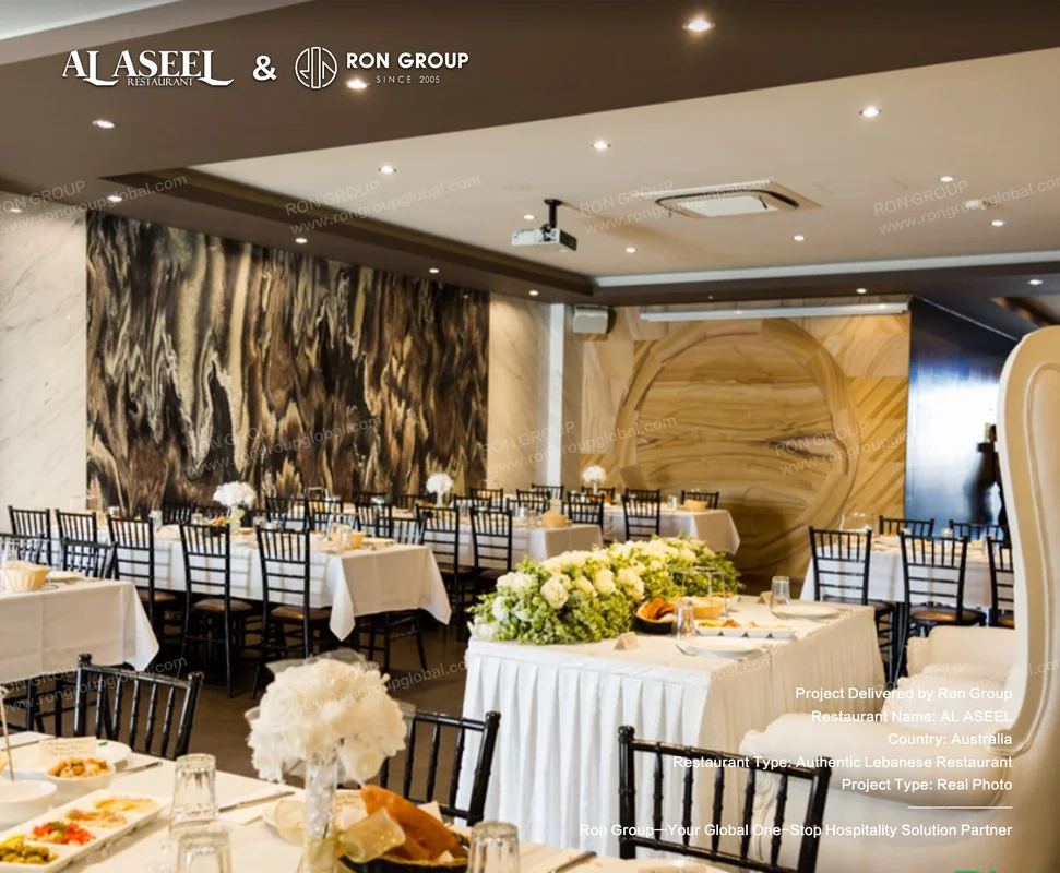 Formal private dining space at Al Aseel with white linen tables black chiavari chairs and marble walls