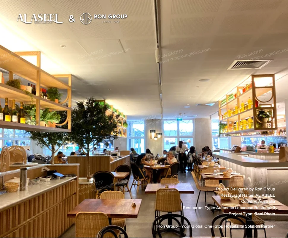 Sunlit Lebanese dining hall at Al Aseel with wooden tables wicker chairs and greenery shelves