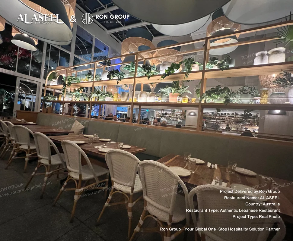 Rustic wooden dining tables woven chairs and tiered ceramic display shelving at Al Aseel
