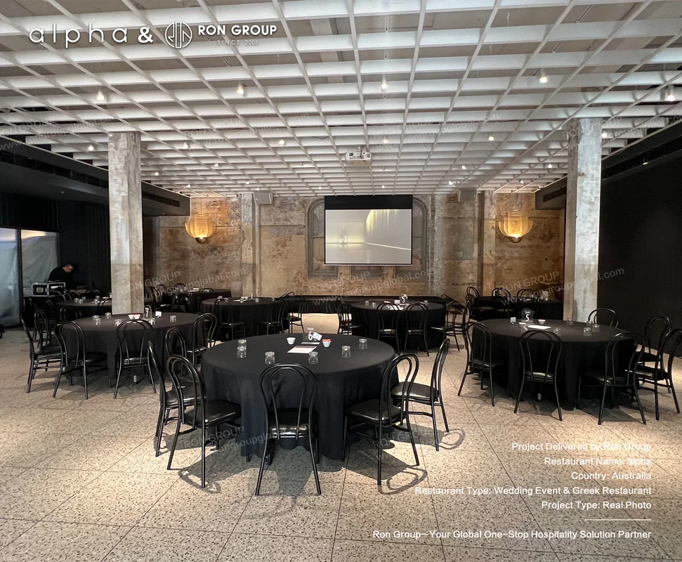 Alpha industrial event space with round banquet tables and black metal chairs