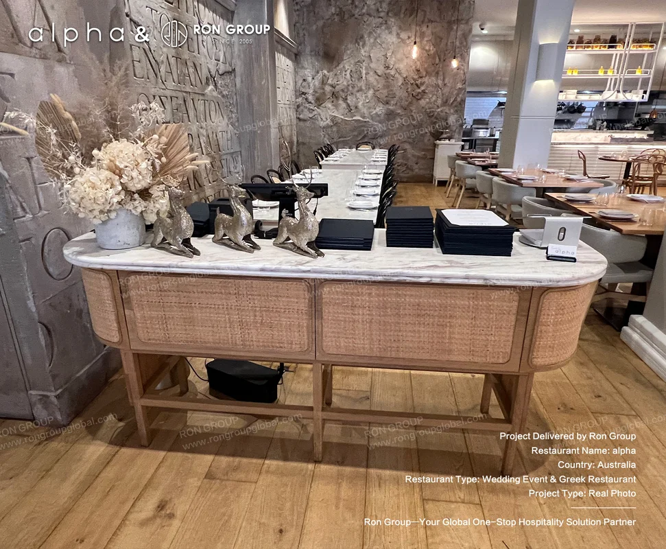 Marble top rattan console table against textured stone wall at Alpha