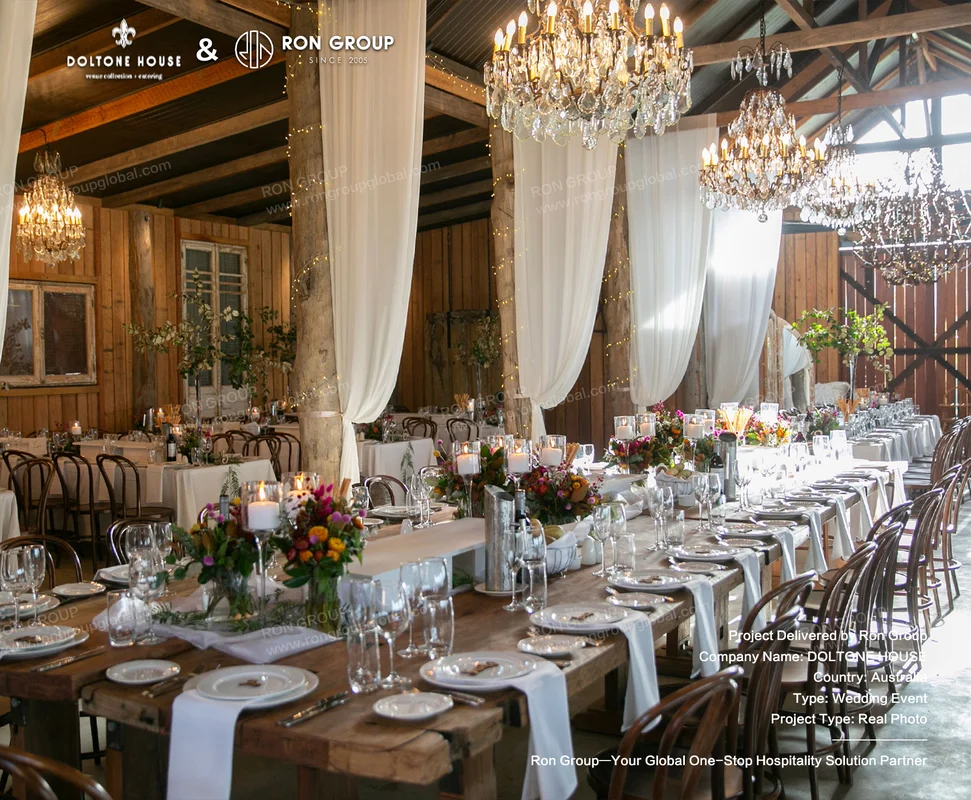 Timber beam wedding hall at Doltone House with long white linen tables and crystal chandeliers