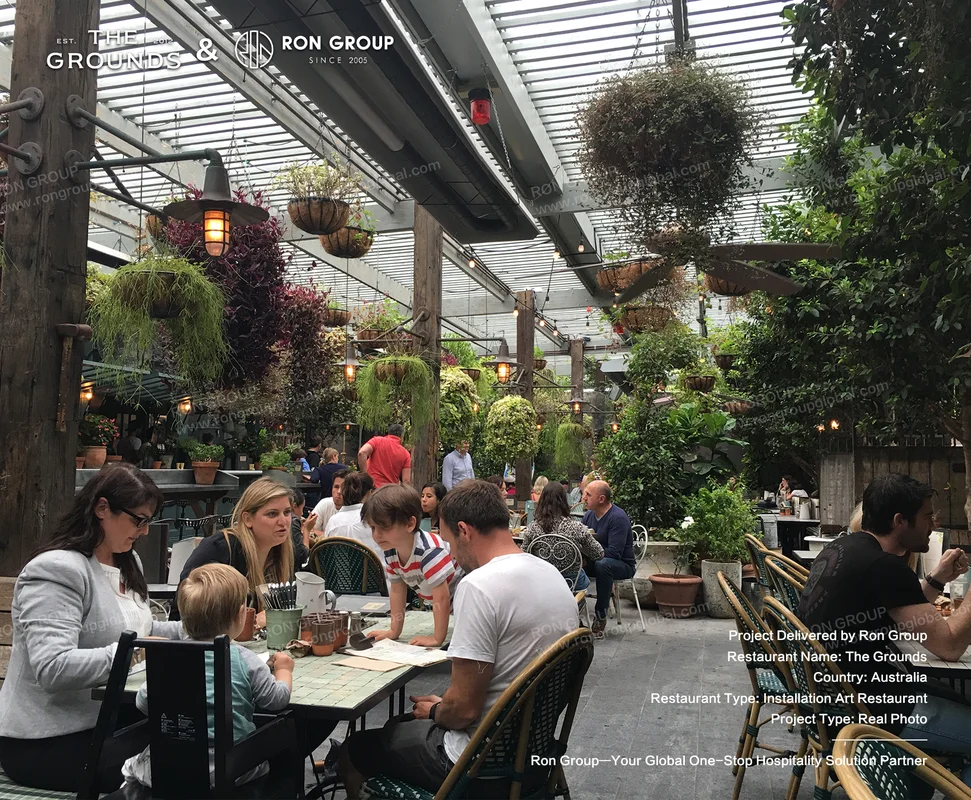 Indoor-outdoor atrium dining space with timber trusses, hanging lanterns, and mosaic tables at Sydney Garden Restaurant
