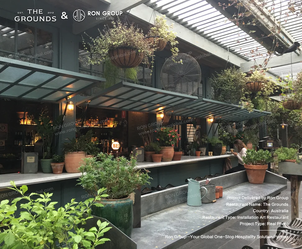 Industrial-chic outdoor bar with hanging plants, terracotta pots, and metal canopy at Sydney Garden Restaurant
